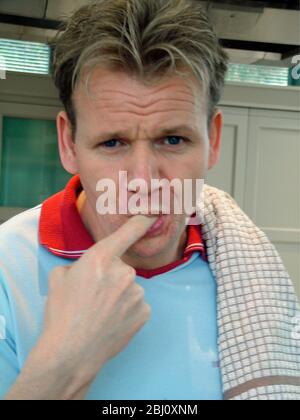 Gordon Ramsay dans sa cuisine maison, dégustation de chocolat pudding - Banque D'Images