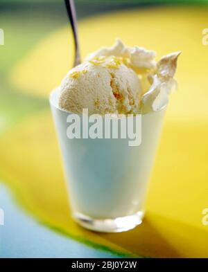 Glace au citron avec meringue écrasée dans un verre dépoli sur fond d'image au citron - Banque D'Images