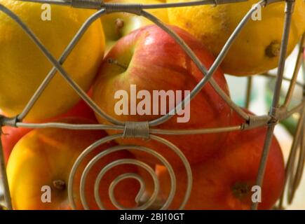 Panier de fruits en fil décoratif avec pommes à manger rouge et jaune - Banque D'Images