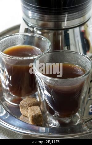 Cafetière expresso électrique avec verres à café en verre isolés avec grumeaux de sucre naturels - Banque D'Images