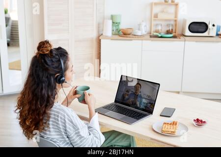 Jeune femme caucasienne et sa collègue asiatique masculine travaillant ensemble sur un projet en cours de conversation vidéo Banque D'Images