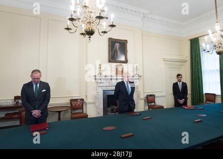 Le Premier ministre Boris Johnson (au centre) est accompagné du secrétaire du Cabinet, Mark Sedchand (à gauche) et du chancelier Rishi Sunak (à droite) dans la salle du Cabinet située dans la 10 Downing Street, à Londres, pour observer une minute de silence en hommage au personnel du NHS et aux principaux travailleurs morts lors de l'éclosion de coronavirus. Photo PA. Date de l'image: Mardi 28 avril 2020. Voir l'histoire de PA SANTÉ Coronavirus Silence. Crédit photo devrait lire: Stefan Rousseau/PA Wire Banque D'Images