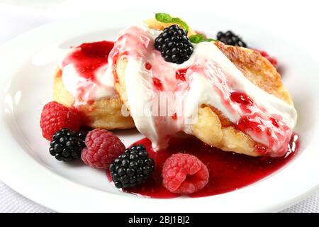 Beignets de fromage cottage avec baies en assiette, fermeture Banque D'Images