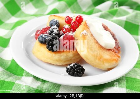 Beignets de fromage cottage avec baies en assiette, fermeture Banque D'Images