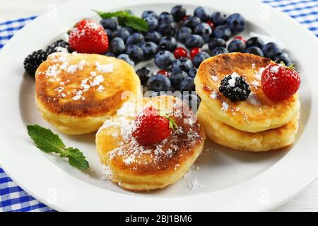 Beignets de fromage cottage avec baies en plaque sur table, ferme Banque D'Images