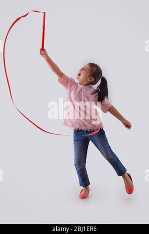 jeune fille jouant avec une baguette de ruban Banque D'Images