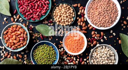 Panorama de l'assortiment de légumineuses, vue en hauteur sur un fond sombre. Lentilles, soja, pois chiches, haricots rouges, une vatiété des légumineuses Banque D'Images