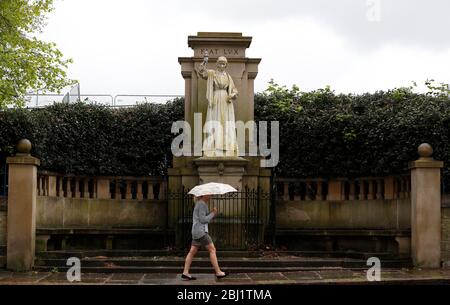 Derby, Derbyshire, Royaume-Uni. 28 avril 2020. Une femme passe devant une statue de Florence Nightingale après que la nation ait observé un silence de minuteÕs pour se souvenir des travailleurs clés morts à cause de Covid-19 pendant le verrouillage de la pandémie de coronavirus. Credit Darren Staples/Alay Live News. Banque D'Images