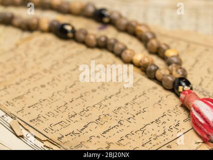 Perles de prière musulmanes avec des pages anciennes du Coran. Concepts islamiques et musulmans. Anciennes feuilles de papier du livre arabe Banque D'Images