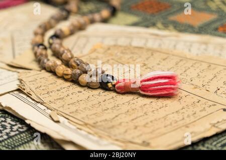 Perles de prière musulmanes avec des pages anciennes du Coran. Concepts islamiques et musulmans. Anciennes feuilles de papier du livre arabe Banque D'Images