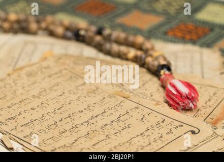 Perles de prière musulmanes avec des pages anciennes du Coran. Concepts islamiques et musulmans. Anciennes feuilles de papier du livre arabe Banque D'Images