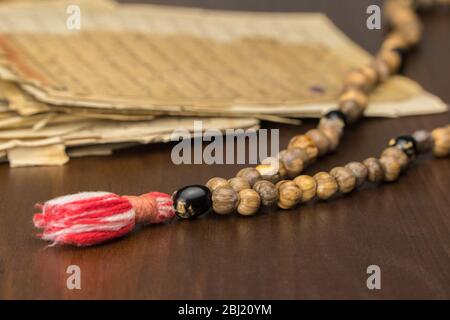 Perles de prière musulmanes avec des pages anciennes du Coran. Concepts islamiques et musulmans. Anciennes feuilles de papier du livre arabe Banque D'Images