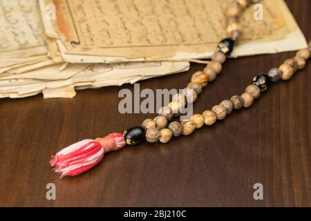 Perles de prière musulmanes avec des pages anciennes du Coran. Concepts islamiques et musulmans. Anciennes feuilles de papier du livre arabe Banque D'Images