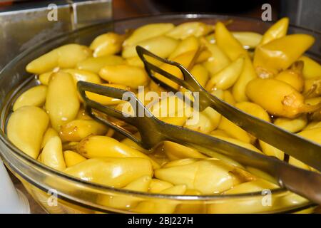 Assortiment de cornichons au soleil pendant la fête de la gastronomie. Légumes marinés comme les poivrons rouges, les concombres, le chou-fleur. Foire de pays ou marché agricole Banque D'Images