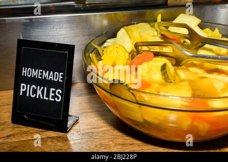 Assortiment de cornichons au soleil pendant la fête de la gastronomie. Légumes marinés comme les poivrons rouges, les concombres, le chou-fleur. Foire de pays ou marché agricole Banque D'Images