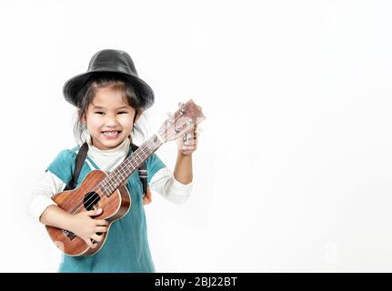 portrait de la petite fille asiatique avec ukulele sur fond blanc Banque D'Images