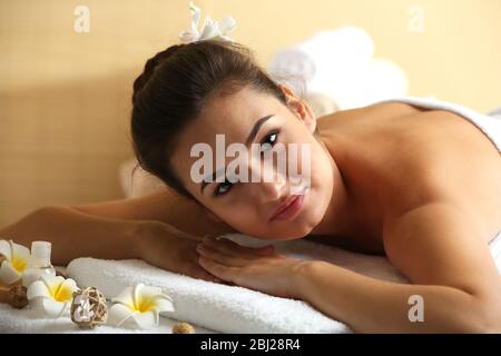 Jeune femme sur table de massage dans le salon de beauté Banque D'Images