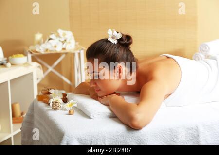 Jeune femme sur table de massage dans le salon de beauté Banque D'Images