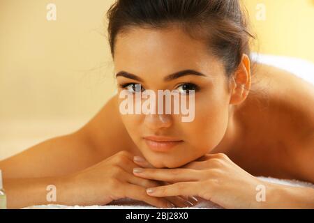 Jeune femme sur table de massage dans le salon de beauté Banque D'Images