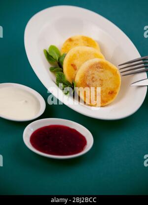 Cheesecakes ronds. Il sert des plats faits maison sur une plaque blanche. Cheesecake à la menthe pour le petit déjeuner, une portion de trois. Appétissant de calcium élevé Banque D'Images