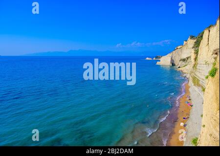 La plage de Loggas à Peroulades est une plage paradisiaque à haute falaise rocheuse blanche et l'eau d'Azur limpide à Corfou, près de Cape Drastis, île Ionienne Banque D'Images