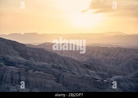 Montagnes et canyons en couches bizarres au coucher du soleil dans le parc du désert Altyn Emel au Kazakhstan Banque D'Images