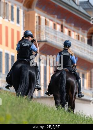 Dresde, Allemagne. 28 avril 2020. Policewomen de la police saxonne patrouille de l'équipe de l'équitation sur leurs chevaux le long des rives de l'Elbe devant le château d'Pilnitz. La police vérifie si les restrictions sont respectées par les citoyens dans la lutte contre la propagation du coronavirus. Crédit: Robert Michael/dpa-Zentralbild/dpa/Alay Live News Banque D'Images