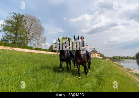 Dresde, Allemagne. 28 avril 2020. Policewomen de la police saxonne patrouille de l'équipe de l'équitation sur leurs chevaux le long des rives de l'Elbe devant le château d'Pilnitz. La police vérifie si les restrictions sont respectées par les citoyens dans la lutte contre la propagation du coronavirus. Crédit: Robert Michael/dpa-Zentralbild/dpa/Alay Live News Banque D'Images