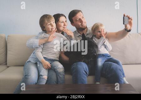 La famille effectue un appel vidéo depuis sa maison Banque D'Images