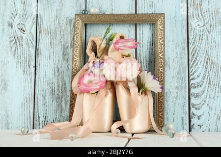 Décoré de chaussures de ballet à fleurs dans un cadre sur fond bleu en bois Banque D'Images