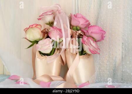 Bouquet de roses en chaussures de ballet sur fond en bois Banque D'Images