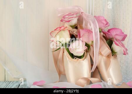 Bouquet de roses en chaussures de ballet sur fond en bois Banque D'Images