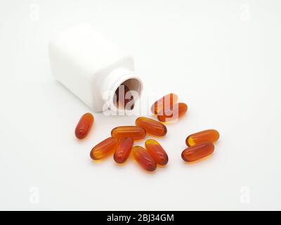 Capsules isolées qui se répandent d'UNE bouteille sur FOND blanc, Londres, Angleterre Banque D'Images