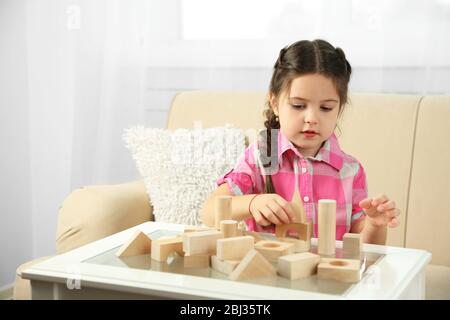 Petite fille jouant avec des cubes sur l'arrière-plan intérieur de la maison Banque D'Images