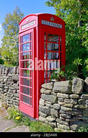 Ancienne boîte téléphonique rouge utilisée maintenant comme bibliothèque gratuite dans le West Yorkshire, Angleterre, Royaume-Uni. Banque D'Images