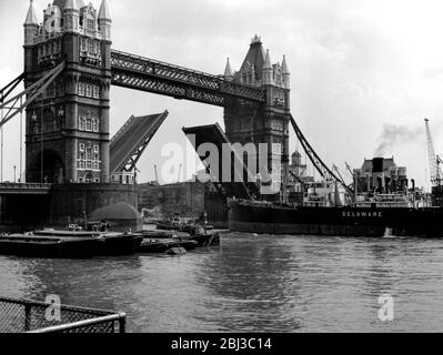 Un navire marchand appelé le Delaware passe sous Tower Bridge à Londres alors que la portée du pont est élevée dans les années 1950 Banque D'Images