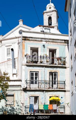 Scène typique de rue portugaise avec buanderie suspendue pour sécher sur les lignes de lavage sur le balcon à Lisbonne, Portugal Banque D'Images