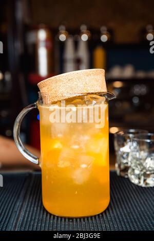 Décanteur transparent avec jus d'orange et glaçons. Banque D'Images