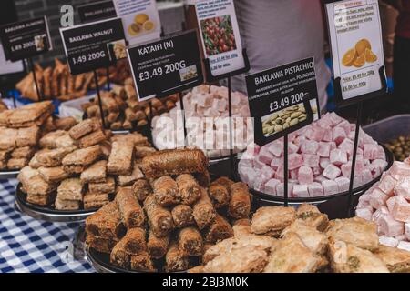 Des pâtisseries du Moyen-Orient, comme la baklava, sont en vente dans un étalage sur un marché de rue à Londres Banque D'Images