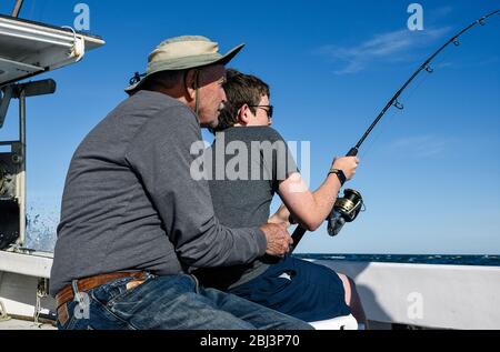Grand-père encourage son petit-fils à pêcher à Chatham sur Cape Cod, dans le Massachusetts. Banque D'Images
