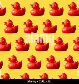 Beaucoup de canards rouges en plastique sur un fond jaune Banque D'Images