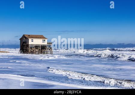 Maison plage de Nags Head sur pilotis entouré par la marée haute tempête surf. Banque D'Images