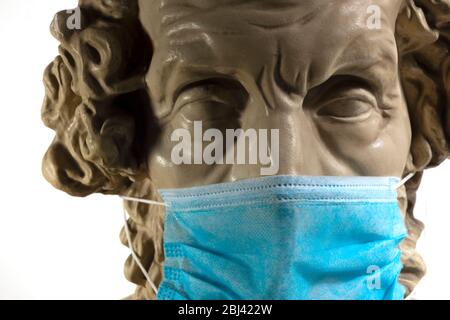 Copie en gypse de l'ancien Homer statue portant un masque de visage de virus Banque D'Images