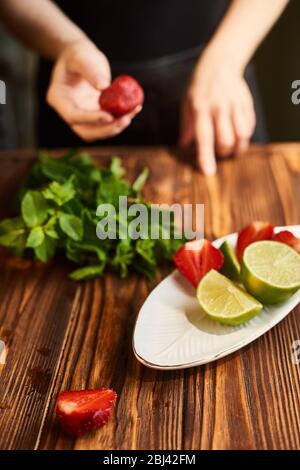 la cuisine du cocktail d'été frais et frais frais avec fraises, glace et menthe et autour des baies sont des fraises et de la chaux mûres Banque D'Images