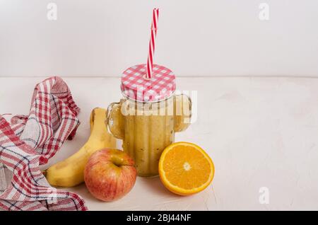 Smoothie aux fruits à base d'ingrédients frais à base de pomme, de banane, d'orange sur fond blanc en bois avec espace de copie. Manger sain, petit déjeuner aux fruits. Banque D'Images