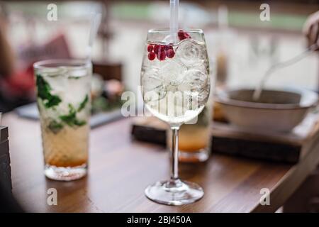 Des cocktails frais d'été avec bulles, chaux, menthe et baies rouges sont sur la table au coucher du soleil. Boissons estivales à l'atmosphère proche. Biélorussie, Minsk Banque D'Images