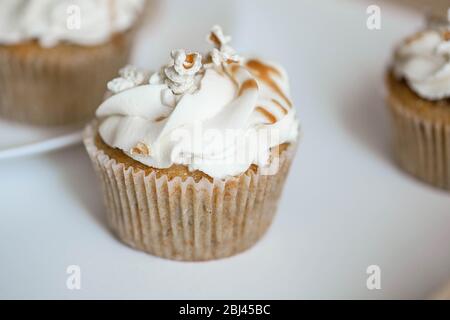 De beaux cupcakes blancs sur une plaque blanche. Banque D'Images
