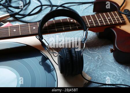 Guitare électrique et casque avec accessoires de musique sur fond gris Banque D'Images
