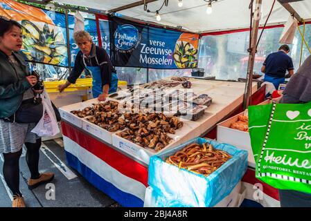 Amsterdam, Pays-Bas - 8 septembre 2018 : vendeur dans une boutique de poissons et fruits de mer avec des gens autour du marché Albert Cuyp, marché de rue à Amsterdam, ne Banque D'Images