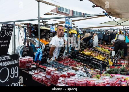 Amsterdam, Pays-Bas - 8 septembre 2018 : vendeur dans une boutique de fruits et légumes avec des gens autour du marché Albert Cuyp, marché de la nourriture de rue à Amste Banque D'Images